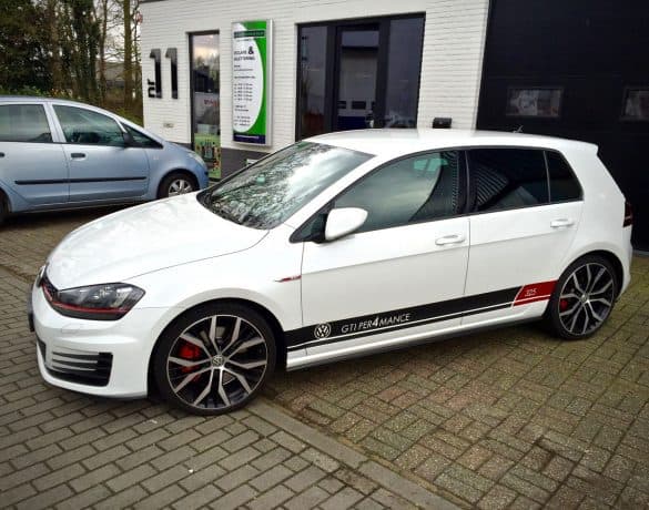 Witte Volkswagen Golf met rode en zwarte accentlijnen langs de flank